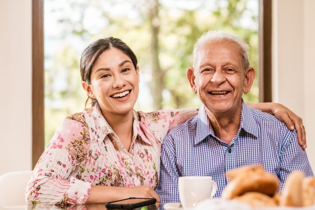 Chisholm Trail Estates | Young Adult and Senior Having Breakfast and Smiling