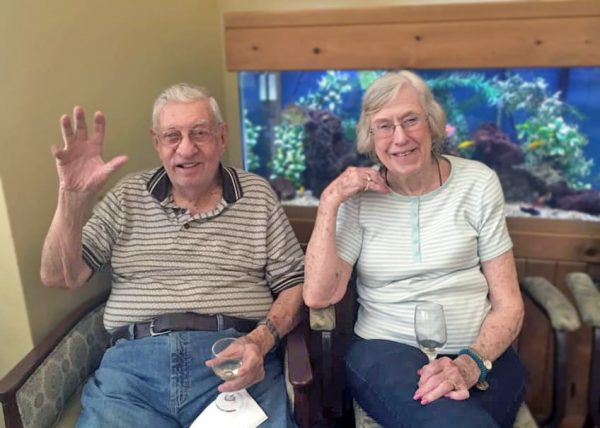 Creston Village | Happy couple waving in front of fish tank