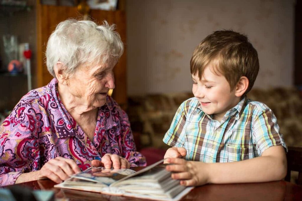 Parmer Woods | Senior woman looking at photo album with child