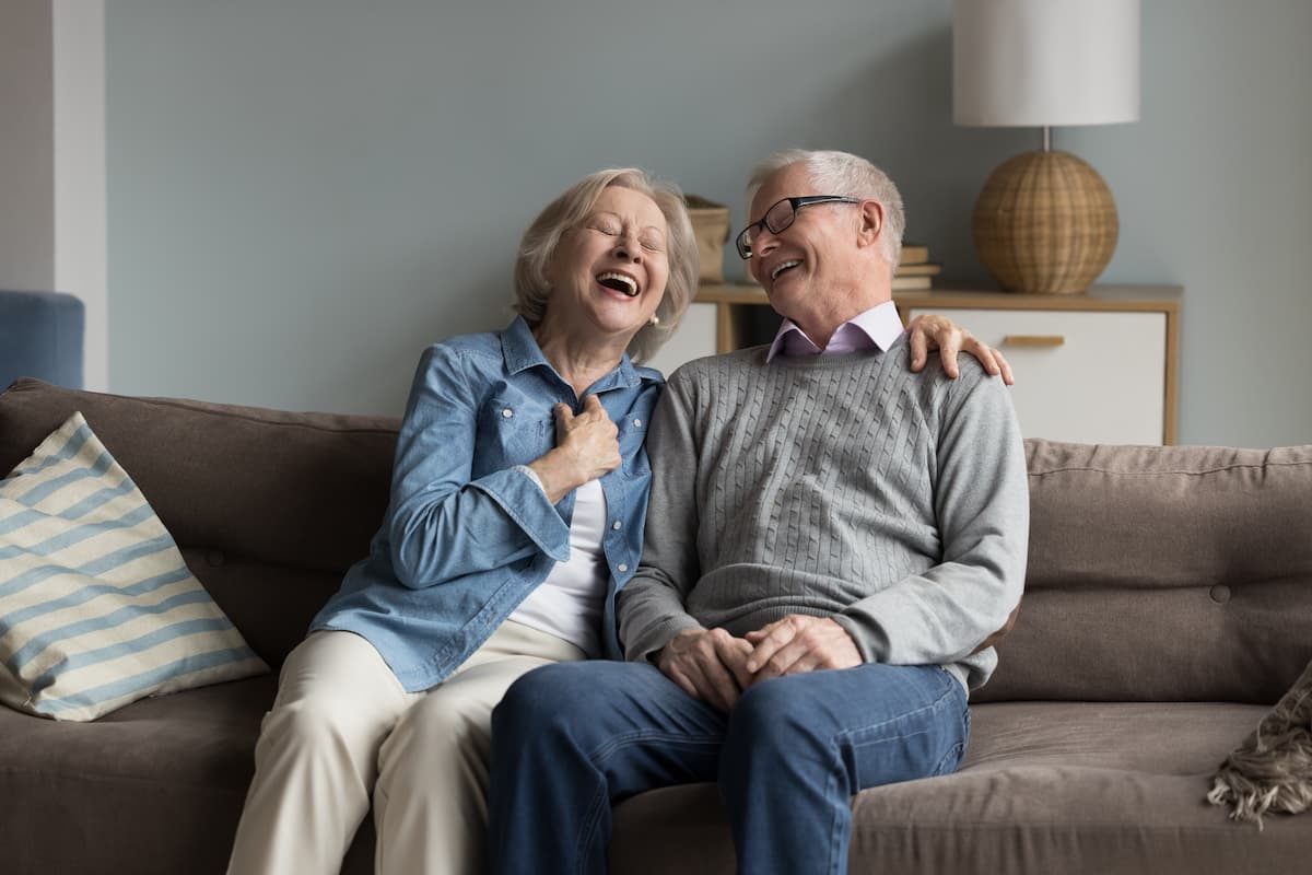 Pegasus Landing of Forney | Seniors Laughing On Their Apartment Sofa