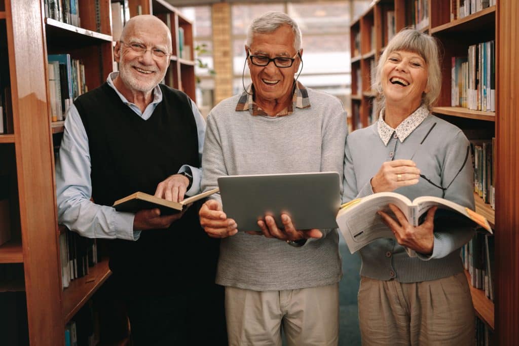 Pegasus Landing of Overland Park | Seniors reading books in library