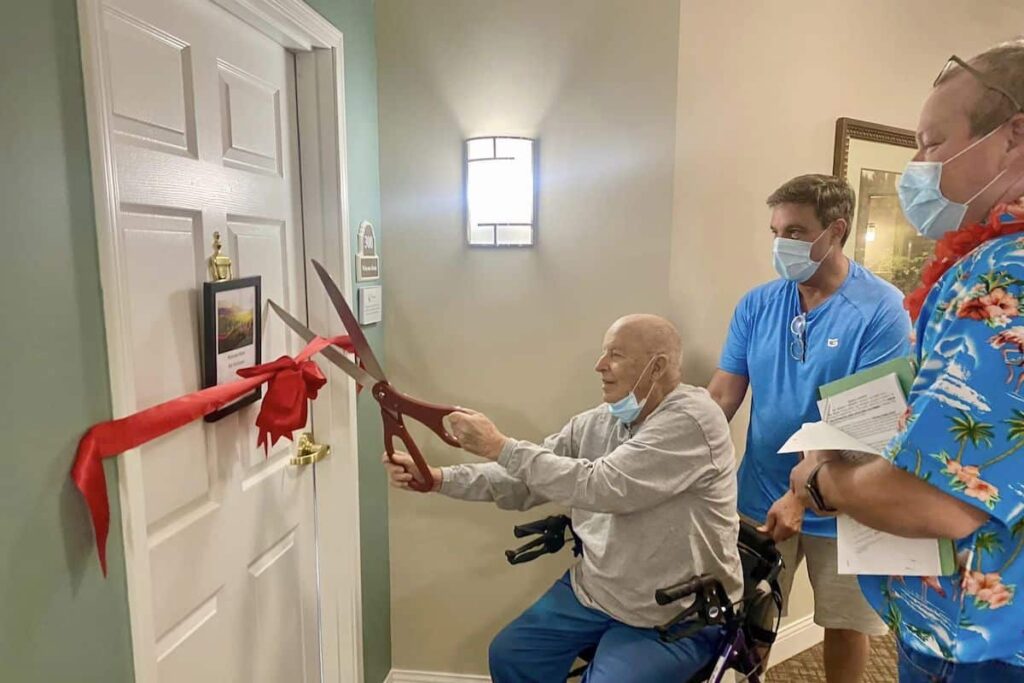 Pegasus Landing Overland Park | Senior cutting ribbon on new apartment