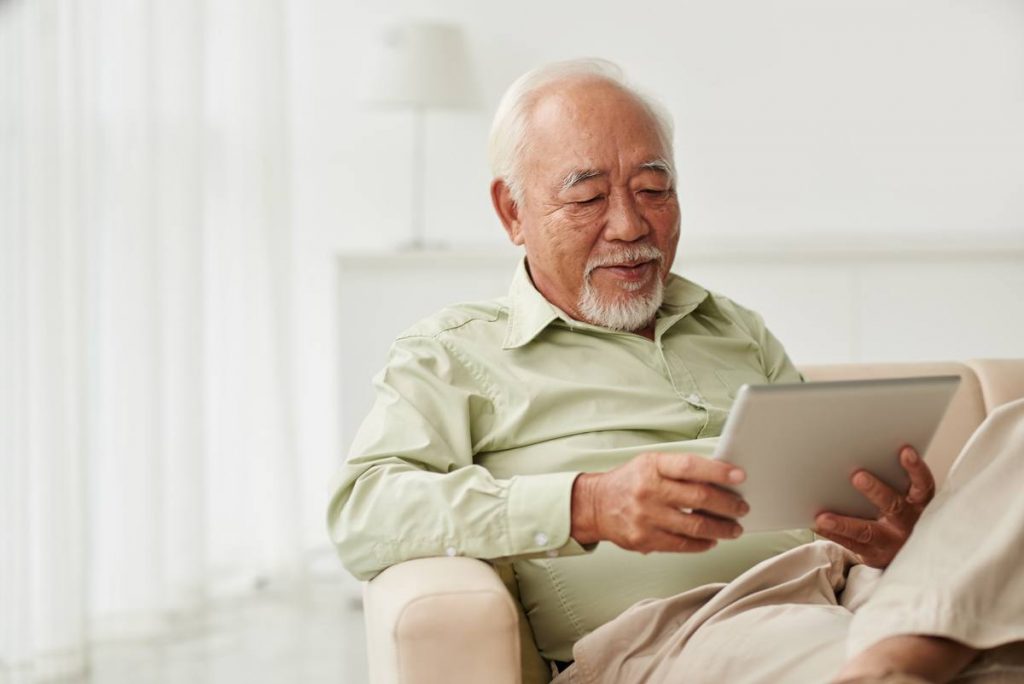 Pegasus Landing of Tanglewood | Happy senior man using tablet