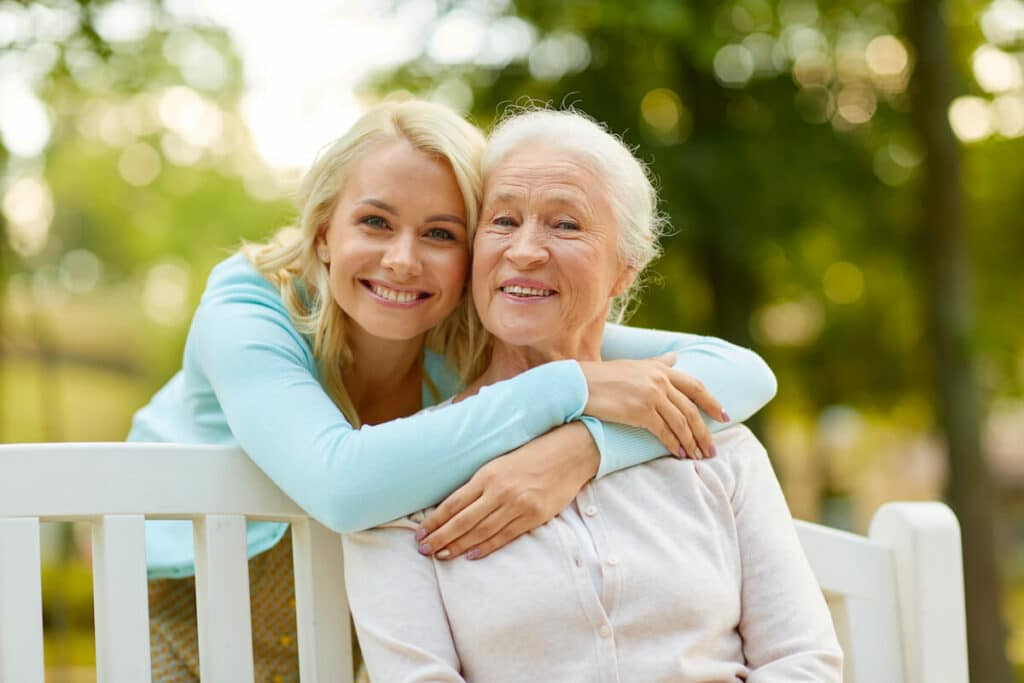 Pegasus Landing of Tanglewood | Senior women and her daughter hugging outside on a bench