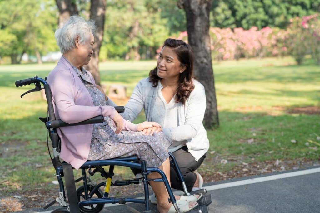 Pegasus Landing of Tanglewood | Dementia caregiver Houston - senior woman in wheelchair with caregiver