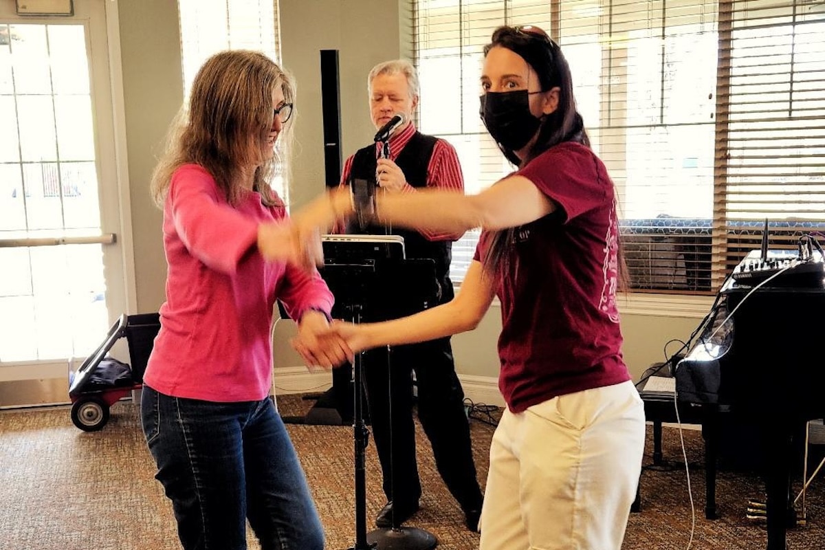 Courtyards at Mountain View | Life Enrichment Director Terry dancing with residents