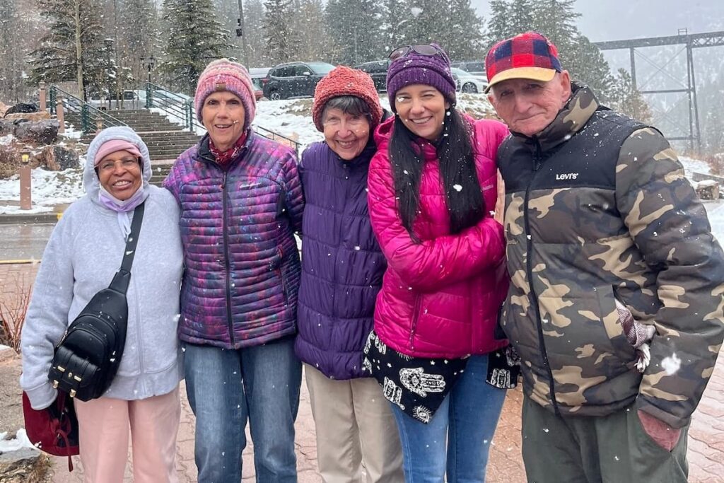 Courtyards at Mountain View | Life Enrichment Director Terry standing in the snow with happy residents