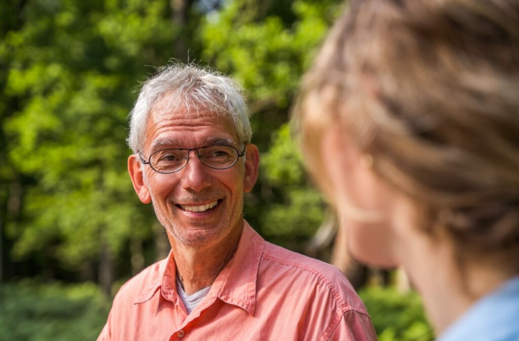 The Legacy at Cimarron in El Paso | Older man smiling outside with his caretaker