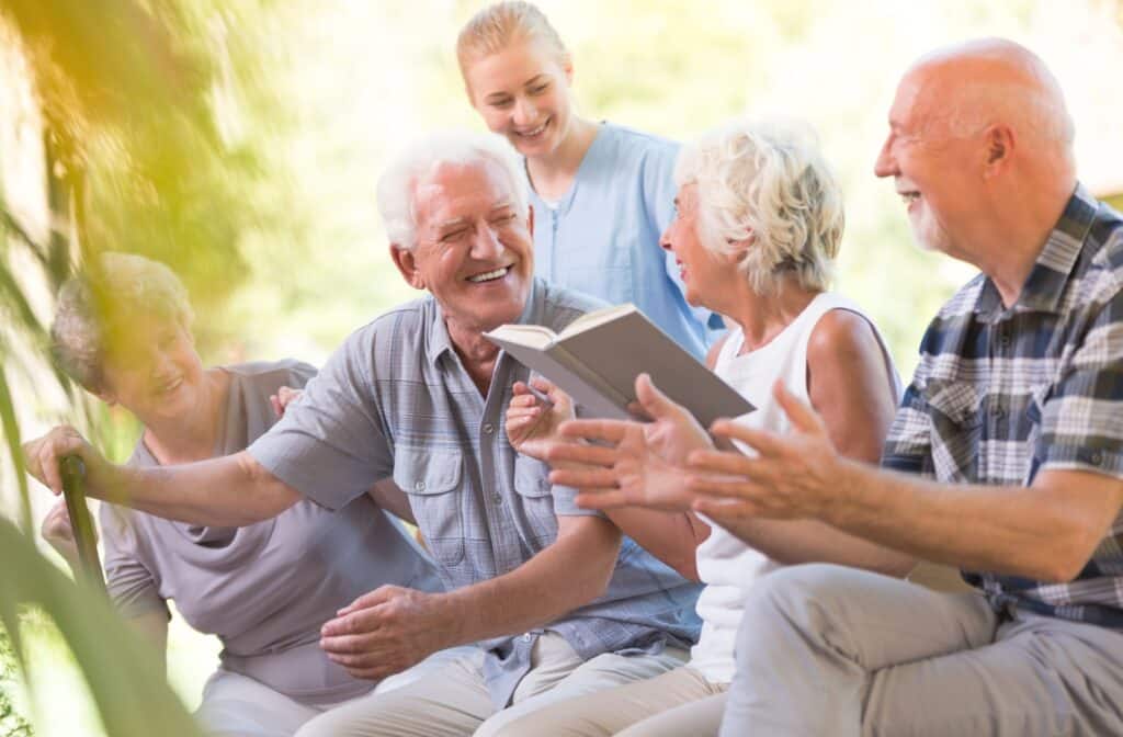 The Legacy at Crystal Falls in Leander | Seniors sitting outside discussing a book