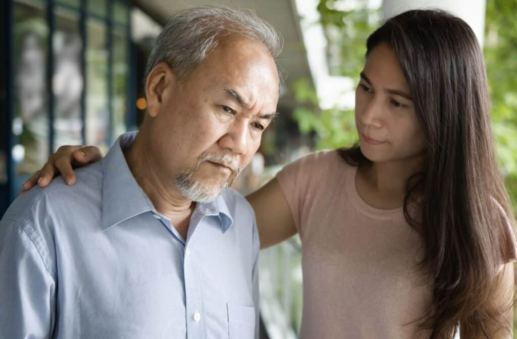 The Legacy At Falcon Point | An adult child rests their hand on their parent with dementia's shoulder.