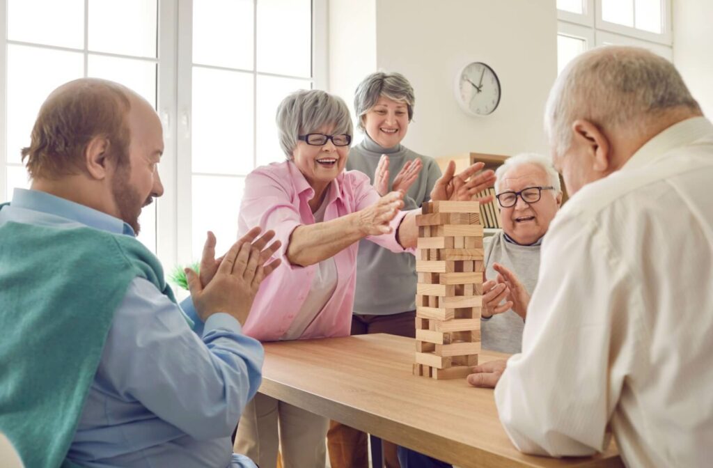 The Legacy At Falcon Point | A group of happy seniors in an assisted living community play Jenga.