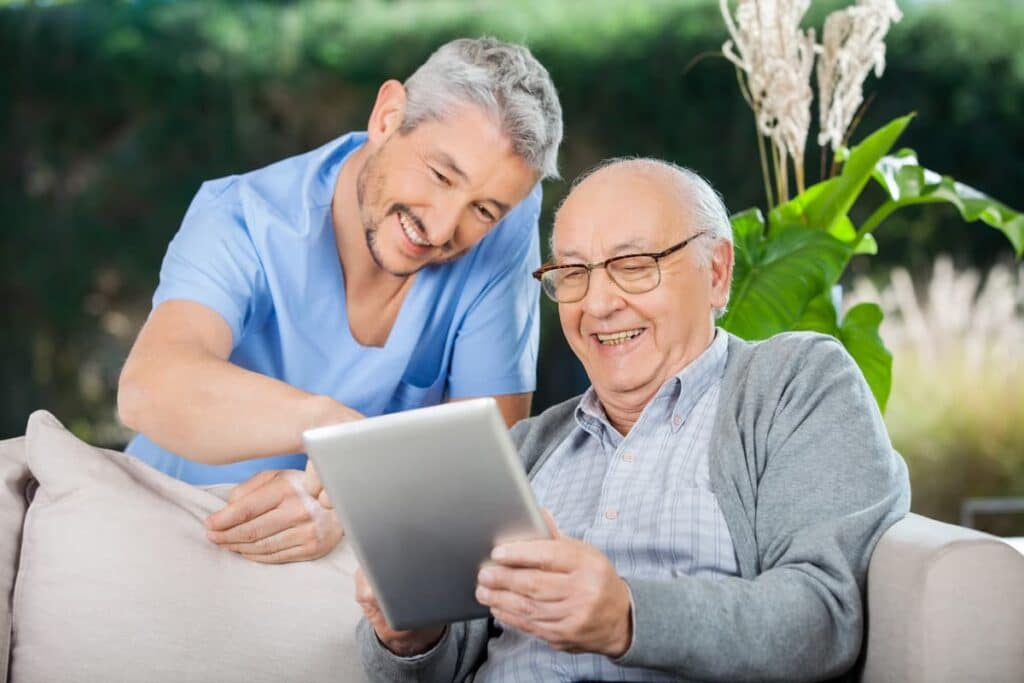 The Legacy at Long Meadow in Richmond | Senior and caretaker reading an ipad