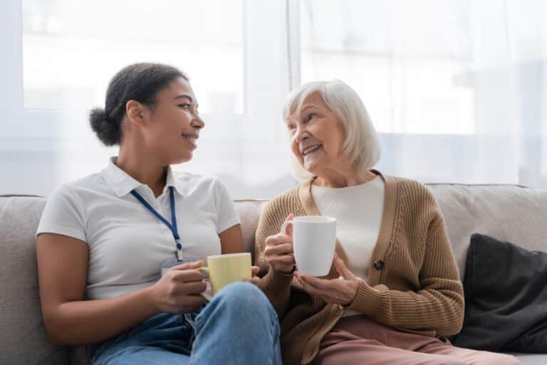 The Legacy at Long Meadow in Richmond | Senior woman and caretaker having coffee