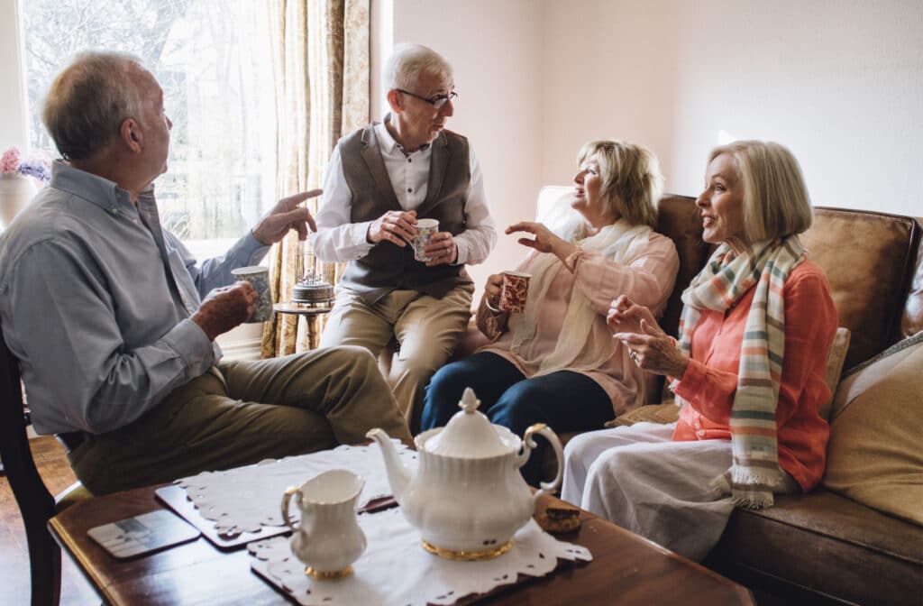 The Legacy At South Plains | A group of seniors sitting a common room, enjoying a pot of tea and socializing