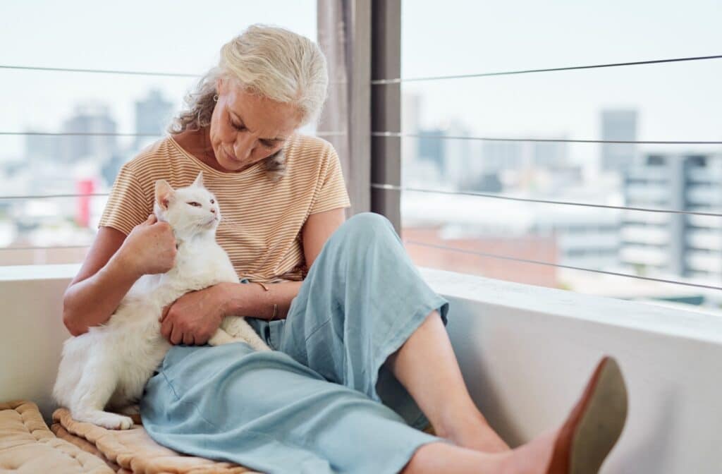 The Legacy At South Plains | An older adult woman holding a white cat at home