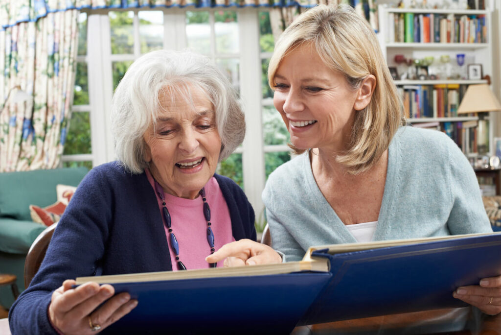 Pegasus Senior Living | Senior woman and her daughter looking though photo album