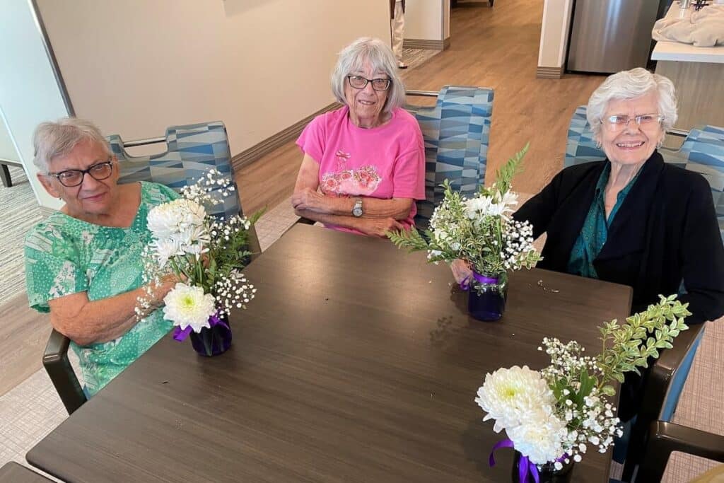 Whispering Winds of Apple Valley | Senior community residents showing their flower bouquets
