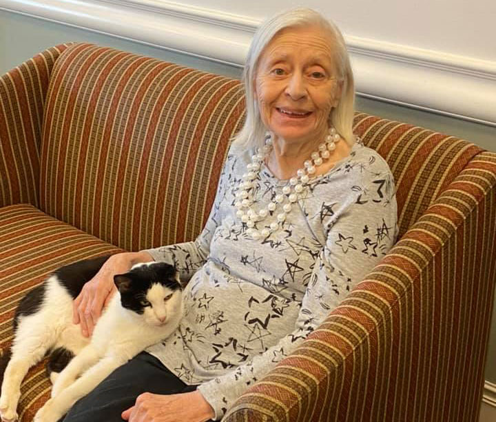 Pegasus Senior Living | Resident at Pegasus Landing of Tanglewood petting foster cat in Houston, TX