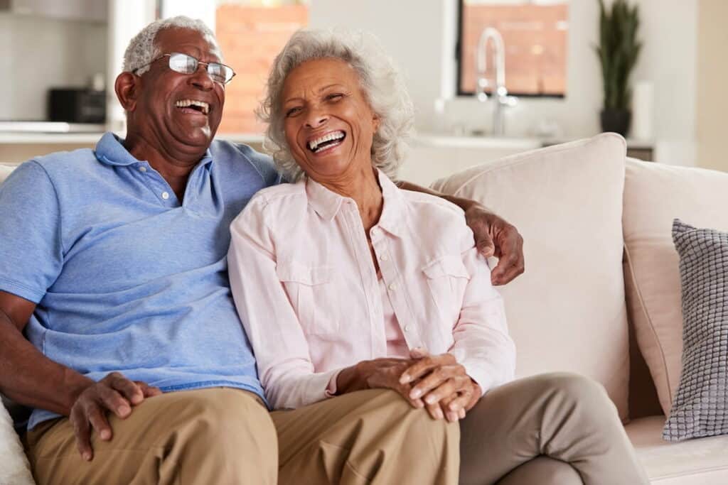 Pegasus Senior Living | Senior Couple Laughing on A Sofa